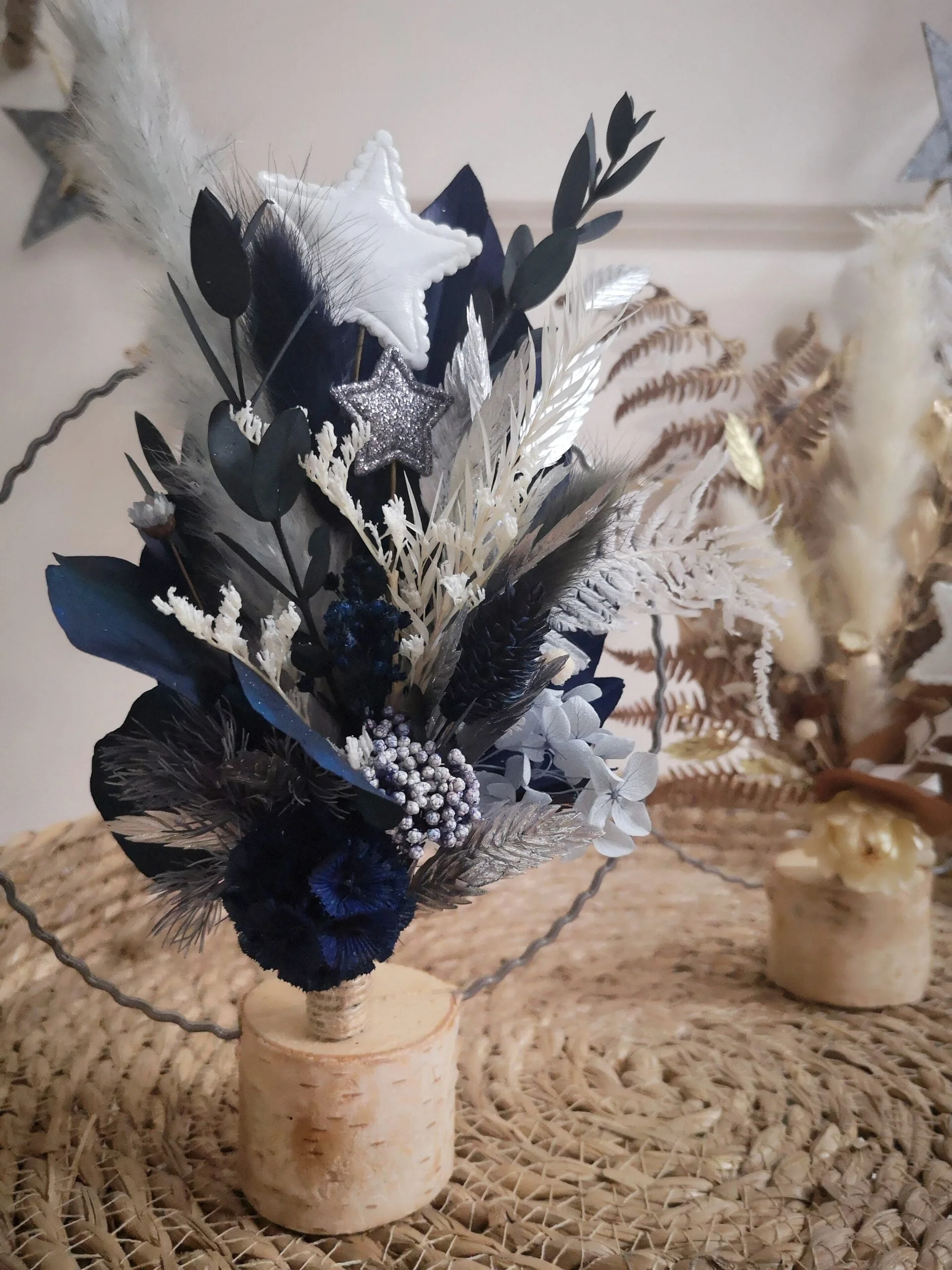 Pour un Noël magique et givré, optez pour le cercle de fleurs séchées “Prince orgeat” à poser qui offre un camaïeu de bleus et des touches argentées.