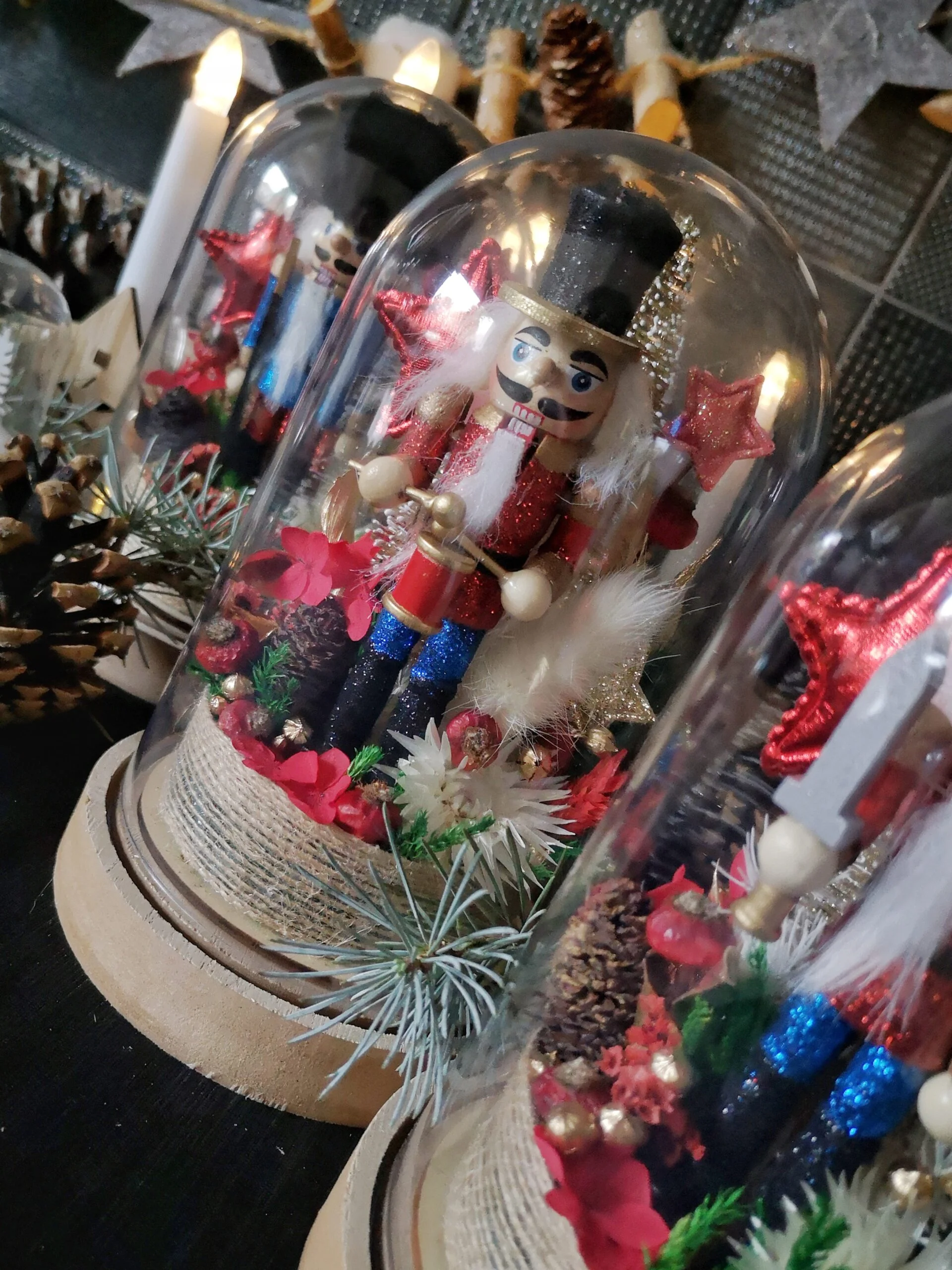 Cloche de fleurs séchées de Noël avec Casse-Noisette pailleté dans les tons rouge, bleu et noir