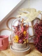 Cloche de fleurs séchées et stabilisées dans les teintes rose, berry, jaune, moutarde