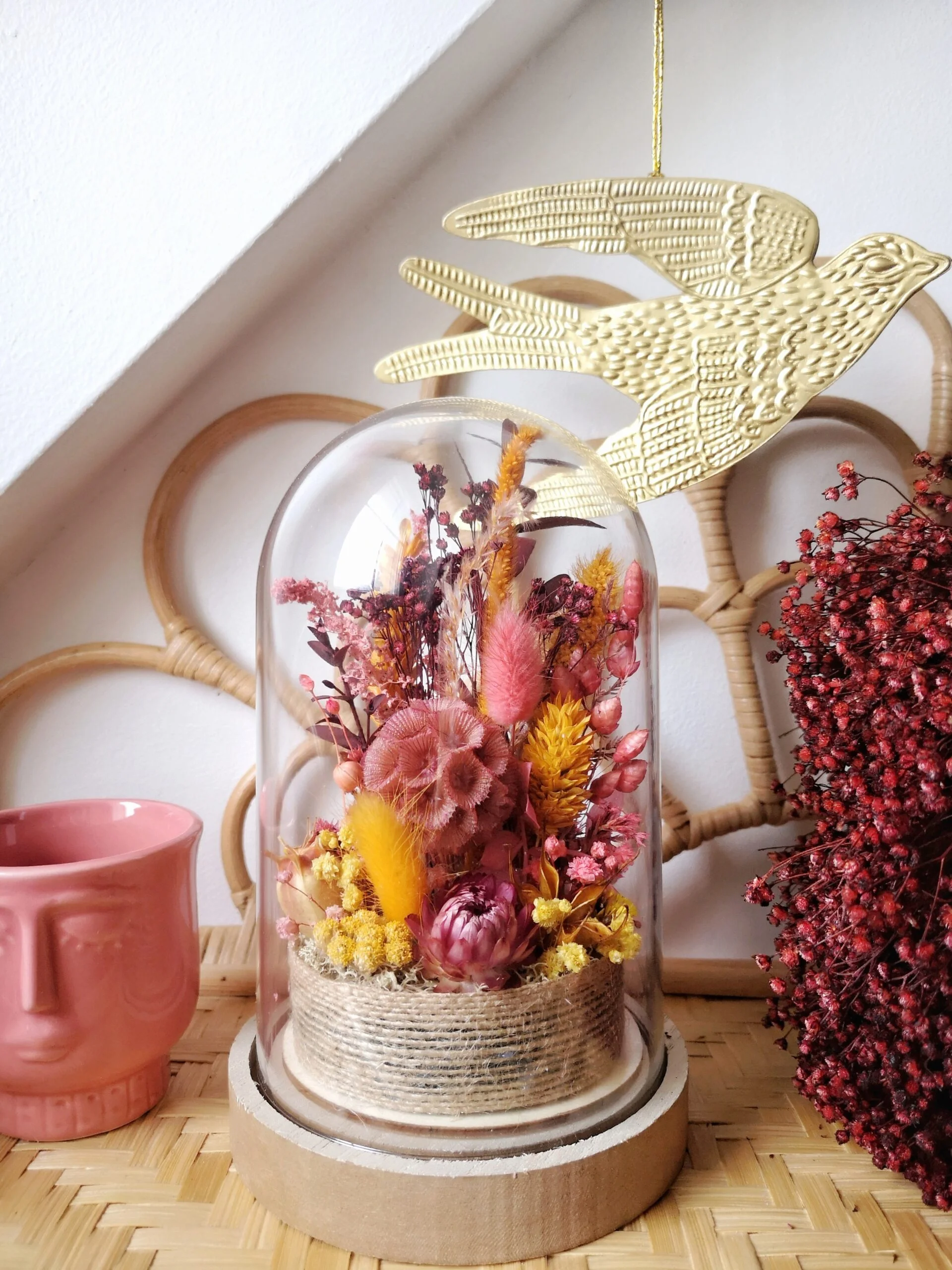 Cloche de fleurs séchées et stabilisées dans les teintes rose, berry, jaune, moutarde