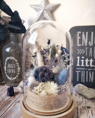 Cloche de fleurs séchées dans les tons bleu et blanc.