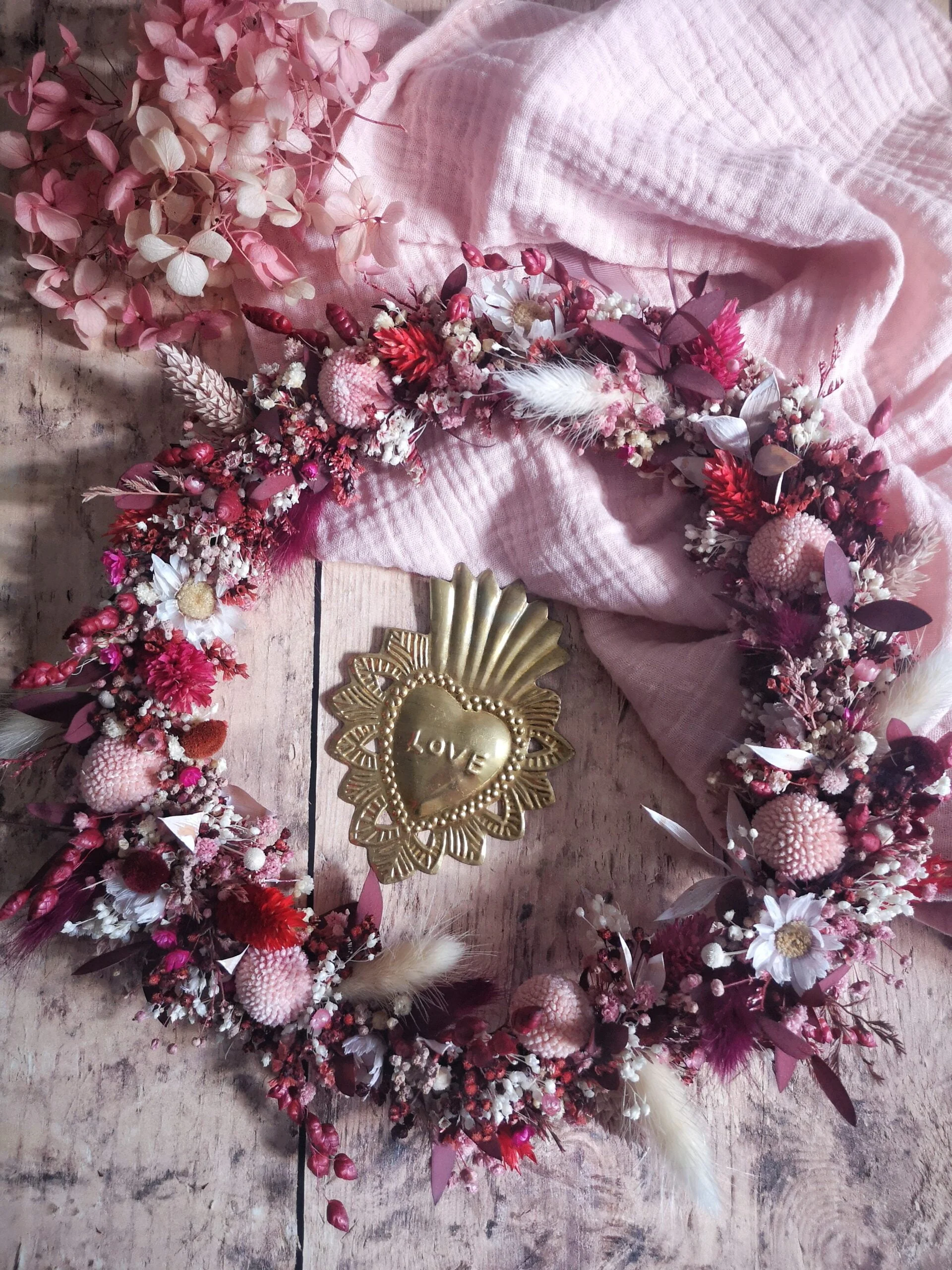 Couronne de fleurs séchées couleurs rose, rouge et crème. Couronne idéale pour habiller un mur ou une porte.