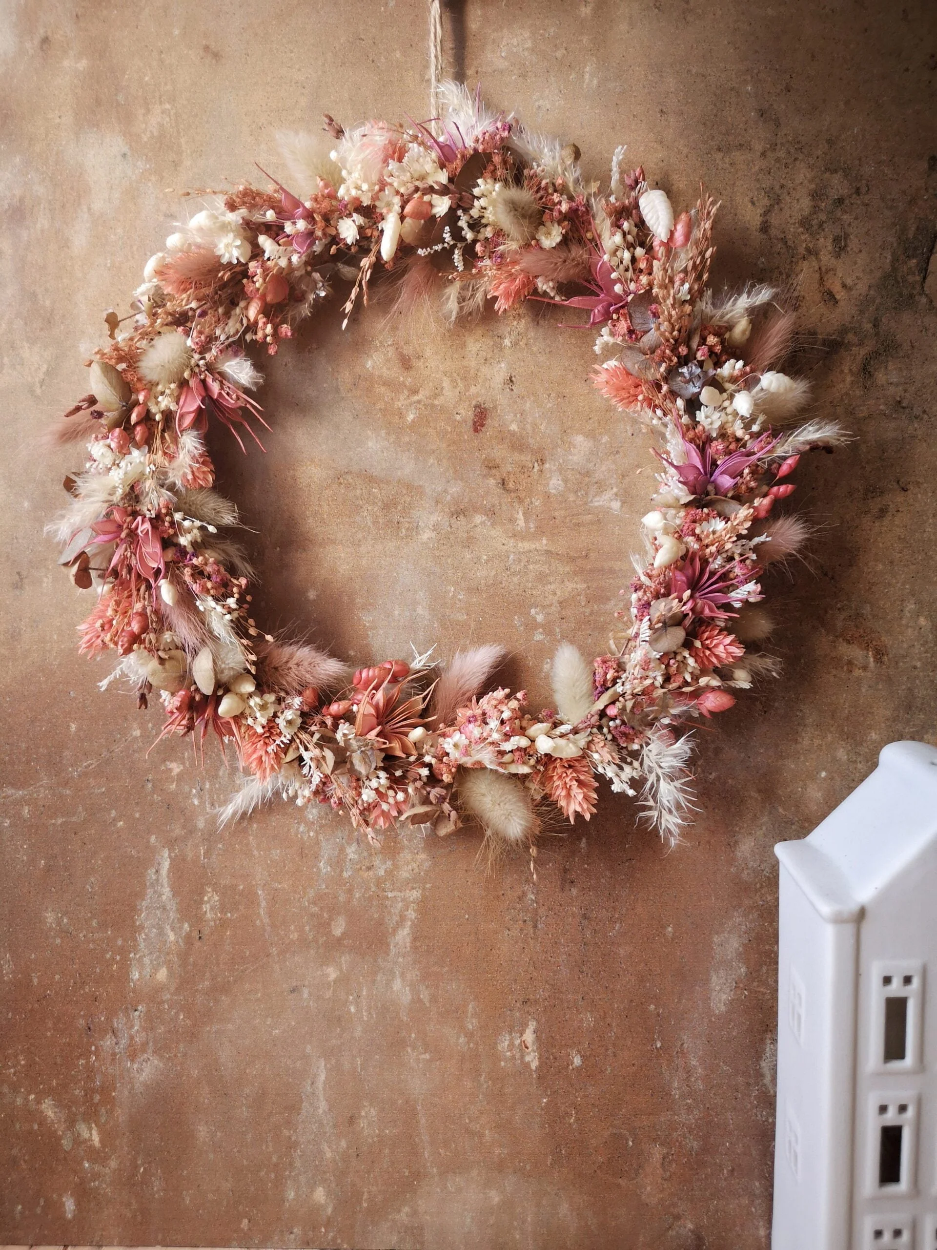Couronne de fleurs séchées murale dans les tons rose et blanc