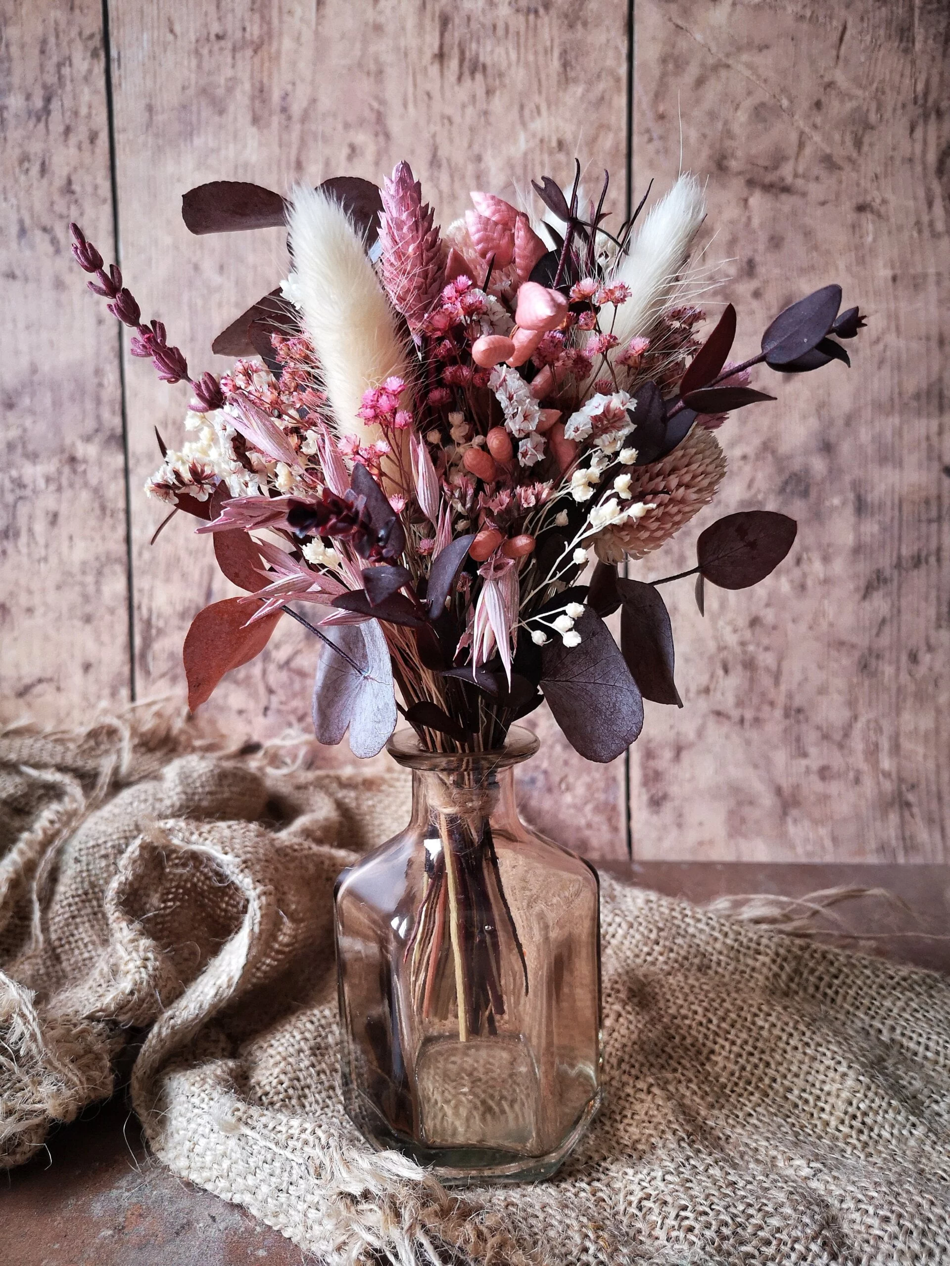 Petit bouquet de fleurs séchées dans les tons bordeaux et crême, fourni avec un joli vase.
