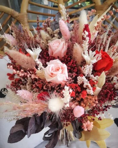 Bouquet de mariée composé de roses, de fleurs séchées et d'eucalyptus