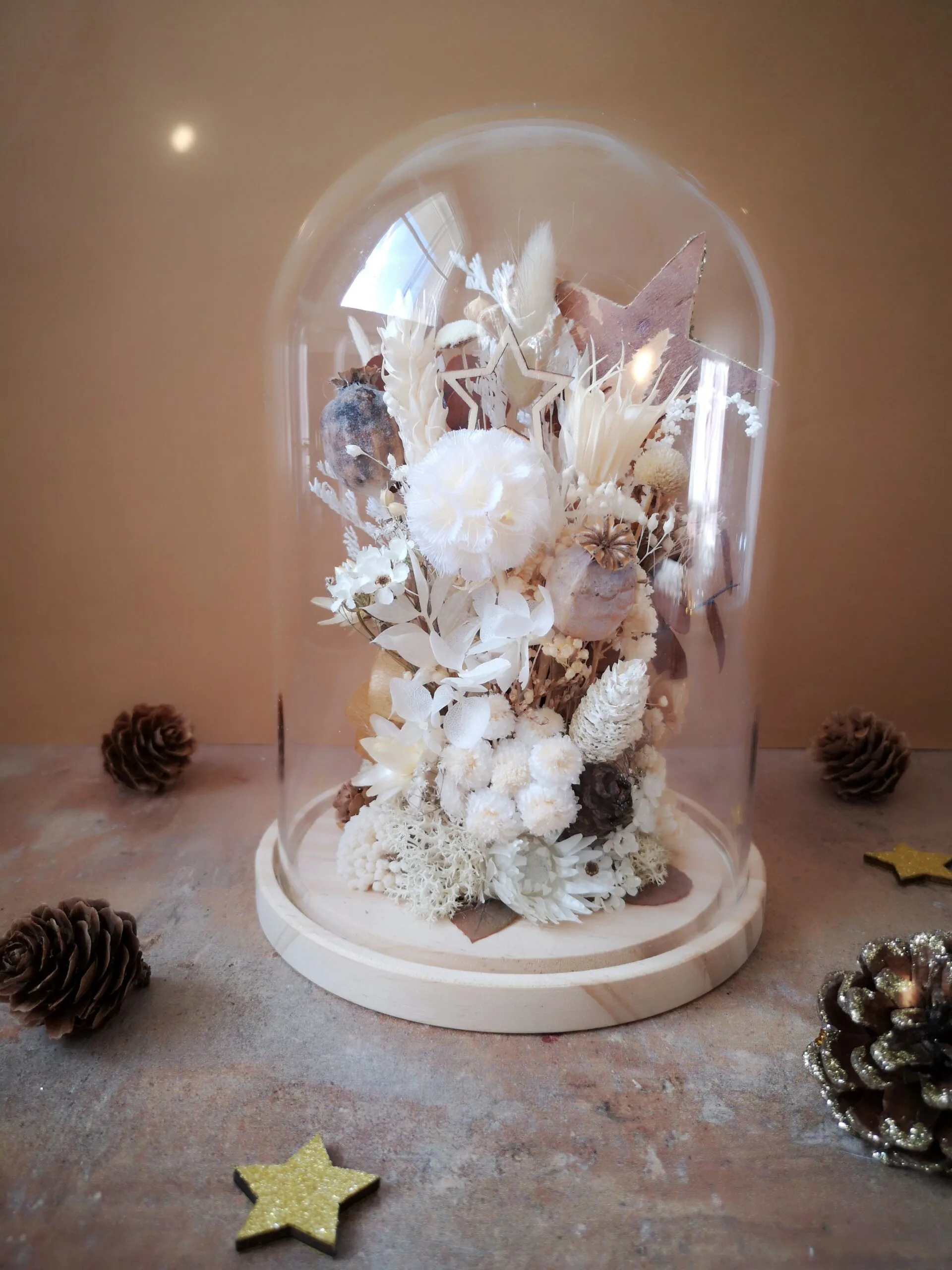 Cloche de fleurs séchées dans des tons naturels (blanc, beige, brun) avec pommes de pin, fleur de coton et étoiles – Image 3