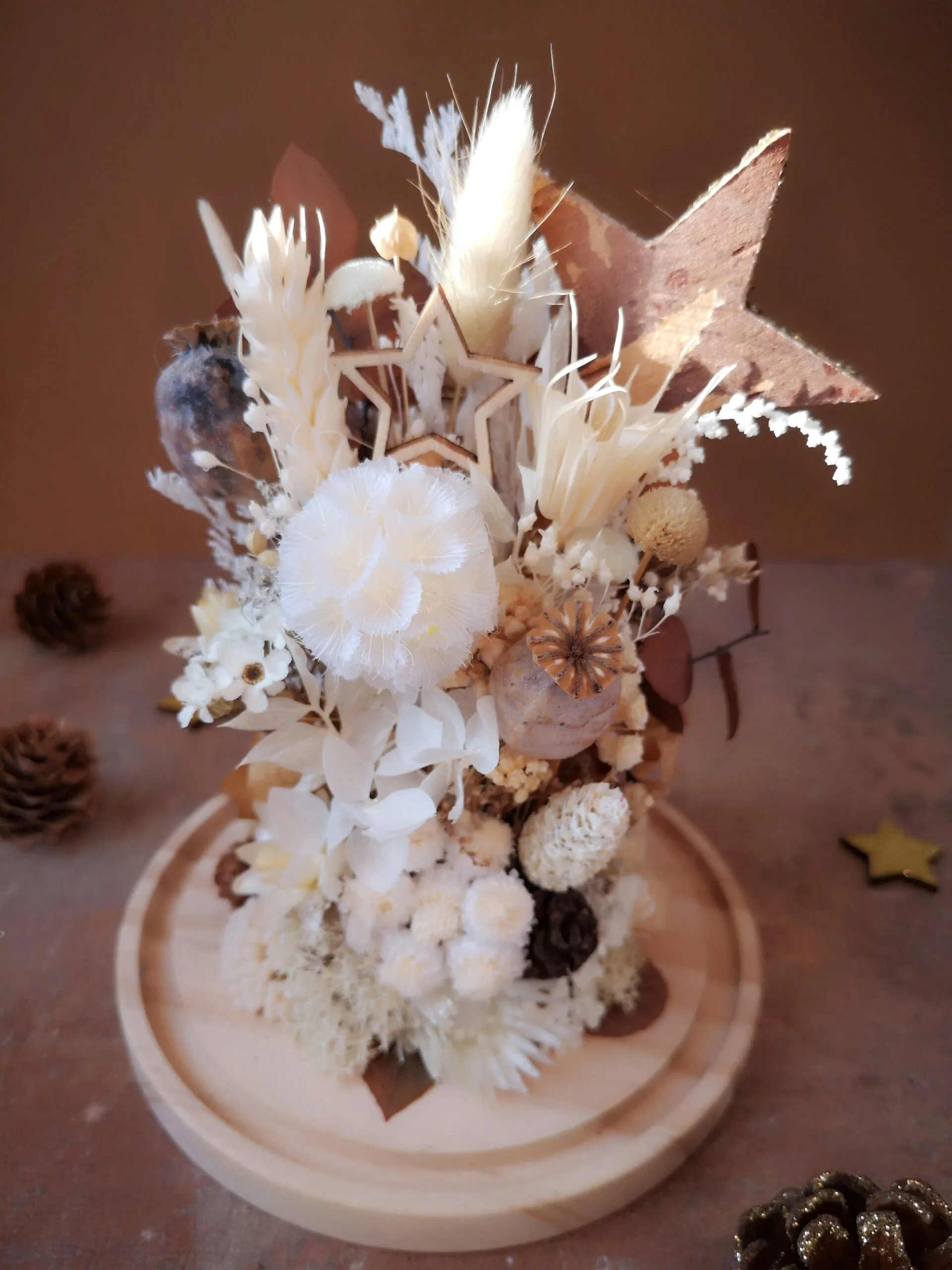 Cloche de fleurs séchées dans des tons naturels (blanc, beige, brun) avec pommes de pin, fleur de coton et étoiles – Image 7